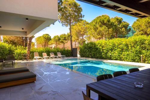 a swimming pool in a yard with a table and chairs at SanPietro Premium Villas in Draçi