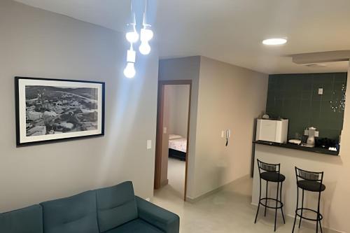 a living room with a couch and two bar stools at Apartamento a 15min do Aeroporto de Confins in Lagoa Santa
