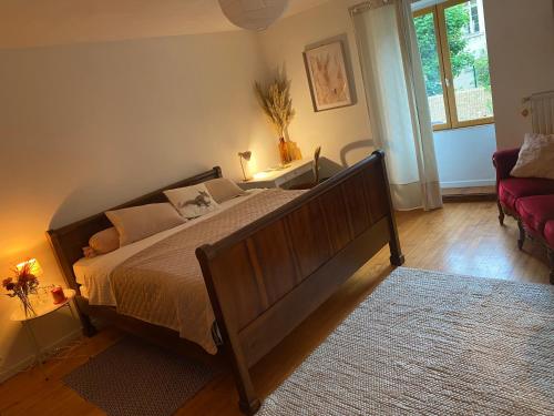 - une chambre avec un grand lit et un canapé rouge dans l'établissement CHEZ LOU, à Bucey-lès-Gy