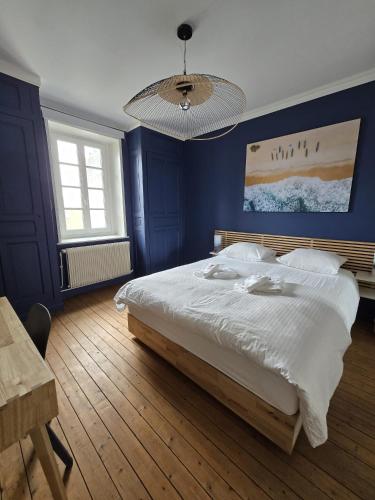 une chambre avec un grand lit avec un mur bleu dans l'établissement Villa sunny Side -Maison 5 chambres, à Le Touquet-Paris-Plage