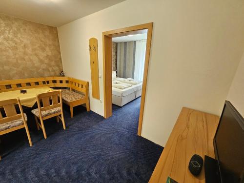 a room with a table and a television and a bedroom at Gasthof goldener Engel in Kemnath