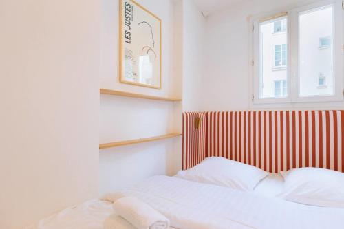 - une chambre dotée d'un lit avec une tête de lit rayée rouge et blanche dans l'établissement Flexliving - Beautiful 3-room apartment with living room - 18th, à Paris