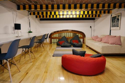 a living room with a red chair and a couch at Habitación privada en el corazón de la colonia Roma in Mexico City