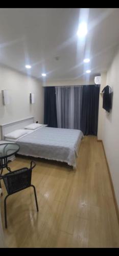 a bedroom with a bed and a chair in it at Orbi Beach Tower in Batumi