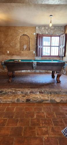 a large table in a room with a stone wall at Casa Ocaso downtown terrace amazing views in San Cristóbal de Las Casas