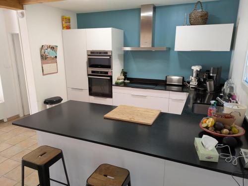 - une cuisine avec un comptoir noir et un bol de fruits dans l'établissement Maison calme a Bastelicaccia a 15 minutes de la plage, à Bastelicaccia