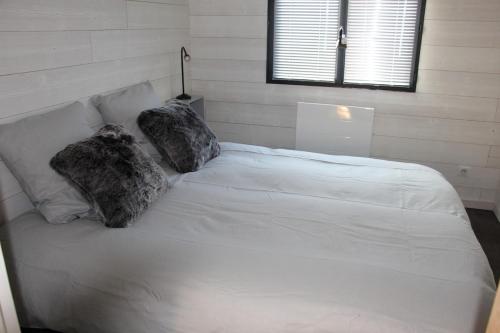 une chambre avec un lit blanc avec deux oreillers dans l'établissement Comme Au Jardin, à Arenthon