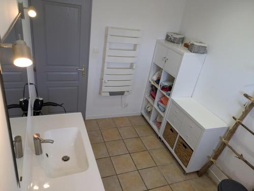 La salle de bains est pourvue d'un évier et d'un réfrigérateur blanc. dans l'établissement Maison calme a Bastelicaccia a 15 minutes de la plage, à Bastelicaccia