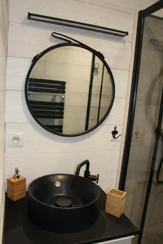 une salle de bain avec un lavabo noir et un miroir dans l'établissement Comme Au Jardin, à Arenthon