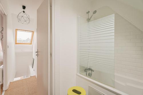 La salle de bains est pourvue d'une douche et d'une fenêtre en verre. dans l'établissement Le 16 - T3 - terrasse proche plage et centre - WIFI, à Saint-Malo