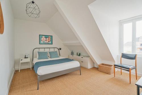 une chambre blanche avec un lit et une chaise dans l'établissement Le 16 - T3 - terrasse proche plage et centre - WIFI, à Saint-Malo