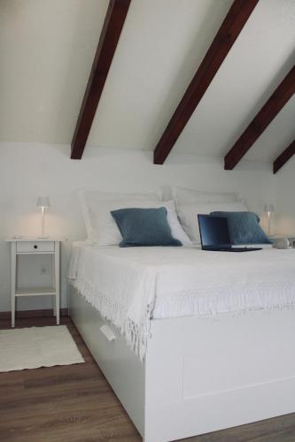 a bedroom with a white bed with a laptop on it at Villa Lando in Peruški