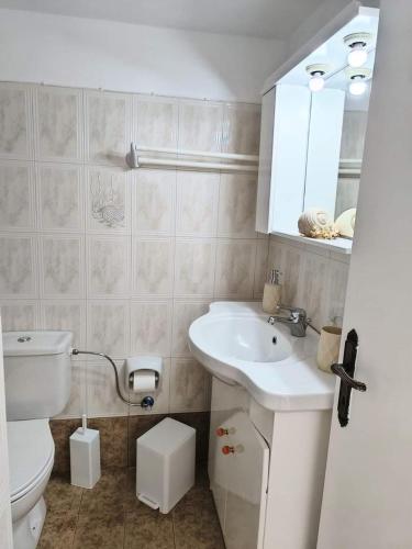 a bathroom with a white sink and a toilet at Anna'sHouse in Agios Ioannis