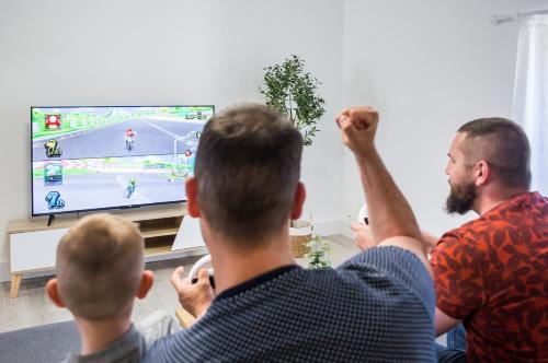 a group of people watching a man play a video game at L'écrin des Forges maison cosy 1 à 6 voyageurs in Cousancelles
