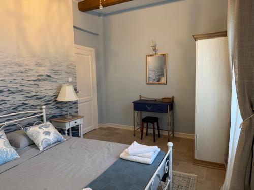 a bedroom with a bed and a desk in it at Carmen's 1st floor Apartment with floor Sea View and roof terrace- Lakones in Lákones
