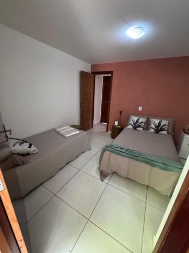 a bedroom with two beds and a red wall at Chalés serra linda in Bananeiras