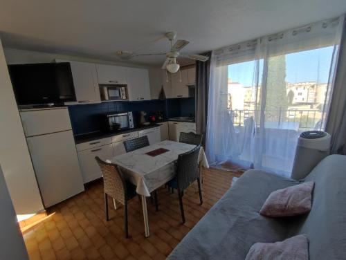 une cuisine et une salle à manger avec une table et des chaises dans l'établissement Appartement T2 avec piscine, proche de la plage et du Port, à Gruissan