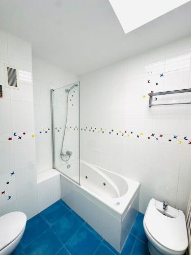 a white bathroom with a tub and a toilet at Prime Location Penthouse with Stunning Sea Views in Salou