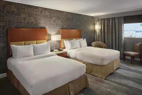 a hotel room with two beds and a chair at DoubleTree by Hilton Akron Fairlawn in Fairlawn