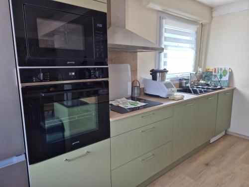 eine Küche mit einem schwarzen Backofen und einer Theke in der Unterkunft La Thibaudière - Maison familiale in Montreuil-Bellay