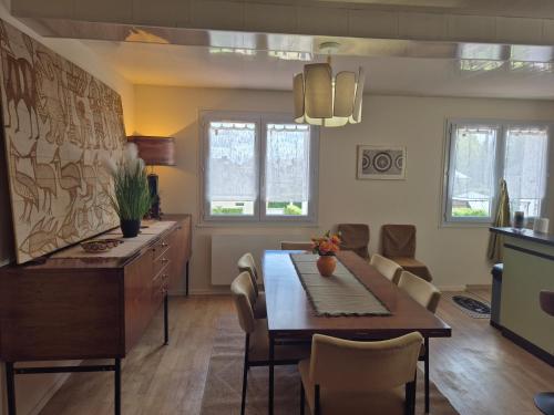 eine Küche und ein Esszimmer mit Tisch und Stühlen in der Unterkunft La Thibaudière - Maison familiale in Montreuil-Bellay