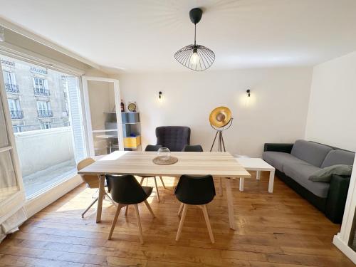 un salon avec une table et un canapé dans l'établissement T2 with Stunning Balcony 55m2 Paris 17, à Paris