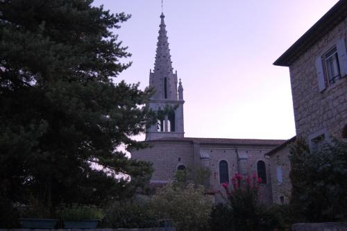 a church with a steeple on top of a building at MAS DUMAS - Maison de village en pierre avec jardin privé in Chandolas