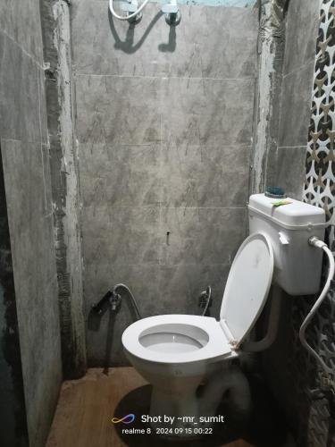 a bathroom with a toilet in a small room at Hari Har guest house in Chhatarpur