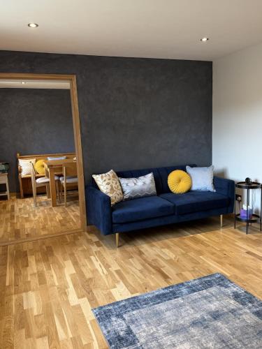 a blue couch in a living room with a table at The Sidings, Wool in Wareham