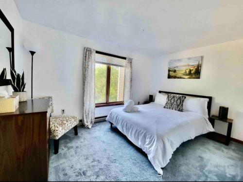 a bedroom with a large white bed and a window at Mountains Getaway in Campton