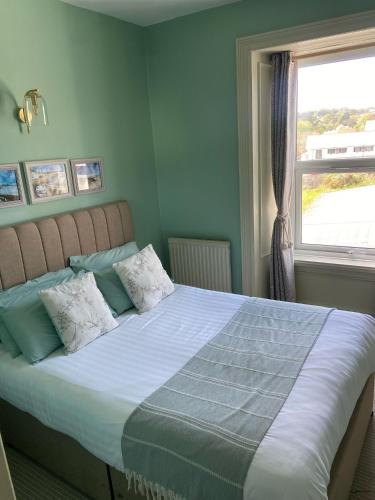 a bedroom with a large bed with a window at The Beach Club in Penzance