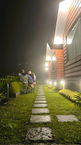 a person laying on a bench in a yard at night at Pondok Alengkong in Bangli