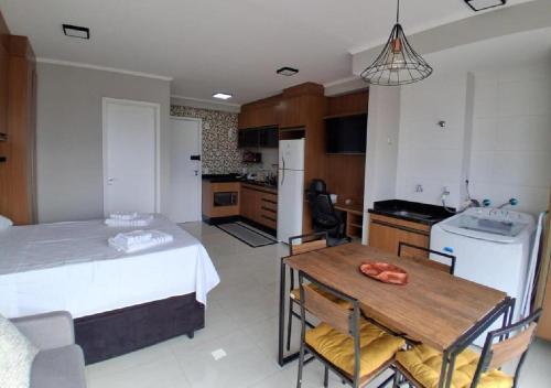 a kitchen and dining room with a table and a bed at 10 minutos do Aeroporto GRU, Ar Condicionado, vaga coberta, vista livre in Guarulhos