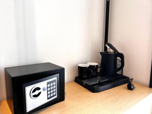 a microwave and a coffee maker on a table at Avenue Hotel in Ksamil