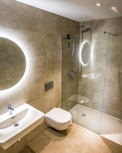 a bathroom with a toilet and a sink and a shower at ENJOYTHEMOMENT Sotavento Suites in La Tejita