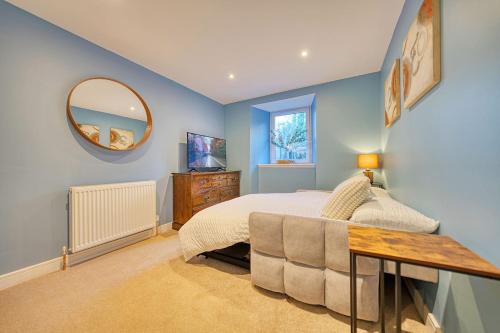 a bedroom with a bed and a mirror and a table at 3-Bed Flat Free Parking 10 Mins to City Centre in Glasgow