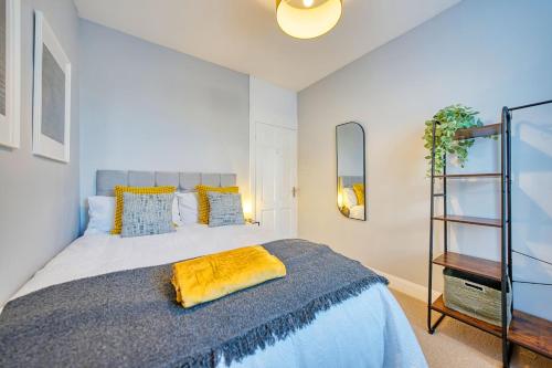 ein Schlafzimmer mit einem Bett mit einer gelben Decke darauf in der Unterkunft 3-Bed Flat Free Parking 10 Mins to City Centre in Glasgow