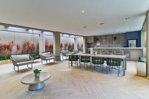 a living room with a table and chairs and a kitchen at Prime Grand Vitrali Moema in Sao Paulo