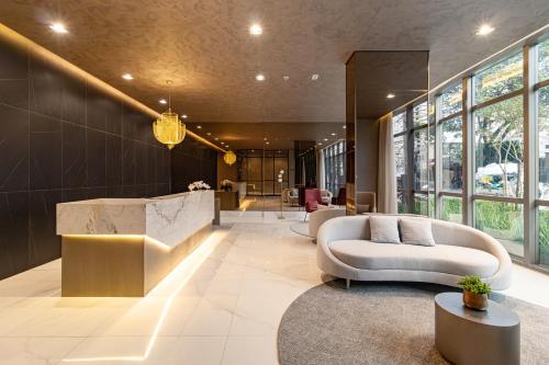 a lobby with a white couch and a table at Prime Grand Vitrali Moema in Sao Paulo
