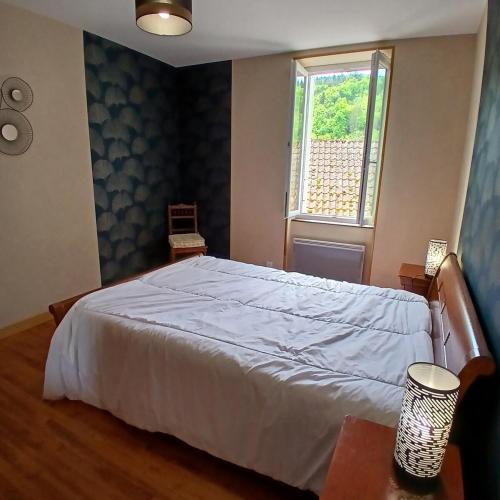 une chambre avec un lit blanc et une fenêtre dans l'établissement Maison calme et paisible, à Châteauneuf-les-Bains