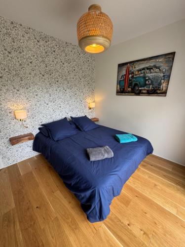 - une chambre dotée d'un lit bleu et d'une peinture murale dans l'établissement VILLA SOULAC ENTRE FORET ET OCEAN, à Soulac-sur-Mer