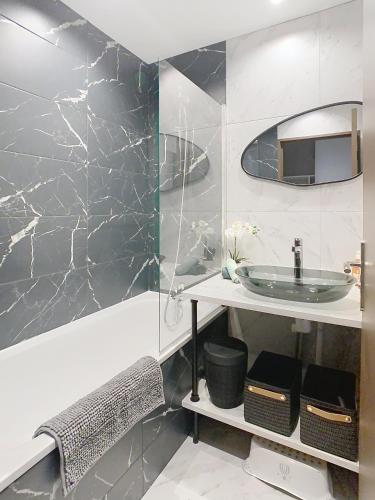 une salle de bain avec un lavabo et un miroir dans l'établissement Le Bucolique, à Montévrain