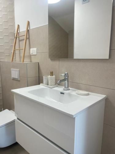 a bathroom with a white sink and a mirror at Pupi Studio Apartment Trogir in Trogir