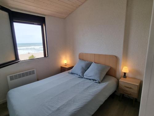 une chambre avec un lit et une fenêtre avec l'océan dans l'établissement Magnifique vue plage joli appartement 5 personnes secteur Allée des Arts, au Barcarès