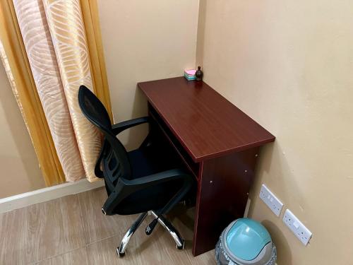 a wooden desk with a black chair next to a wall at Lovely and cozy 2 bedroom apt with oceanic view in Roger