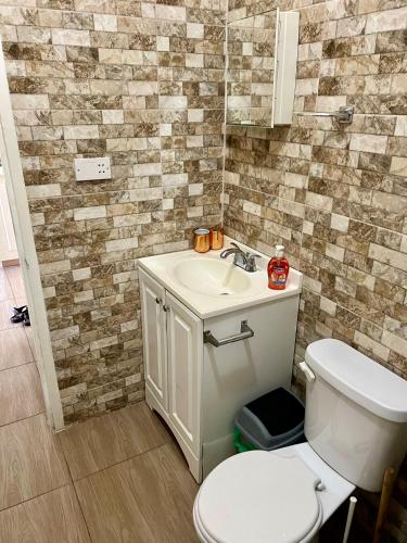 a bathroom with a white toilet and a sink at Lovely and cozy 2 bedroom apt with oceanic view in Roger