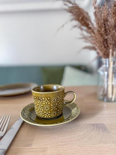 a gold coffee cup and a plate on a table at Strandbad Steckborn mit Herberge, Camping & Glamping in Steckborn