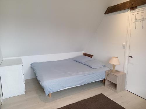 - une chambre blanche avec un lit et une lampe dans l'établissement T2 lumineux refait à neuf, au calme, jardin partagé, à Amiens