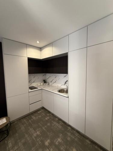 a kitchen with white cabinets and a sink at Apartments & Rooms Villa Zaad FREE PRIVATE PARKING in Mostar