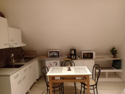 une cuisine avec une table et des chaises dans l'établissement T2 lumineux refait à neuf, au calme, jardin partagé, à Amiens